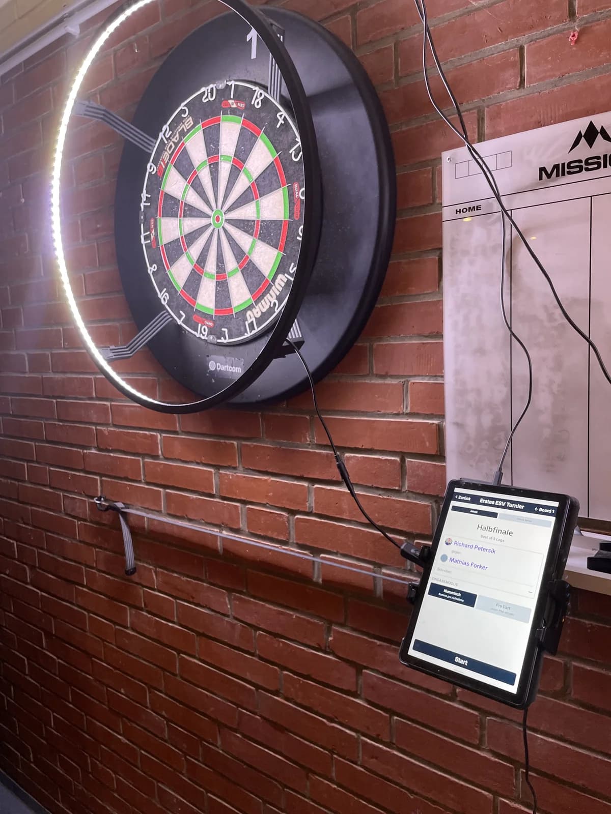 Dartboard mit Beleuchtungsring und gekoppeltem Tablet im Vereinsheim